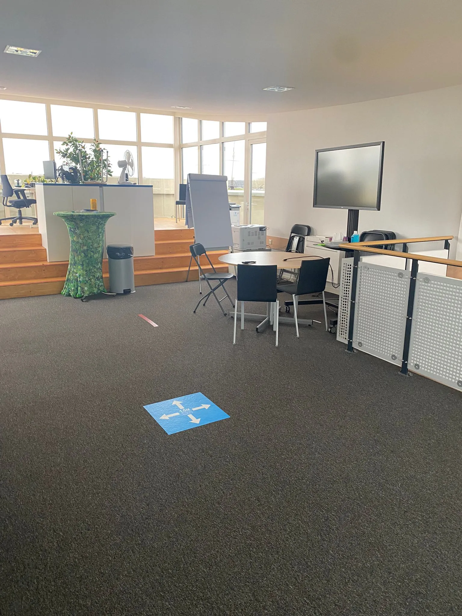 Een moderne kantoorruimte aan de Prins Hendrikkade met werkplekken, een presentatiescherm, flip-over en overlegtafel.